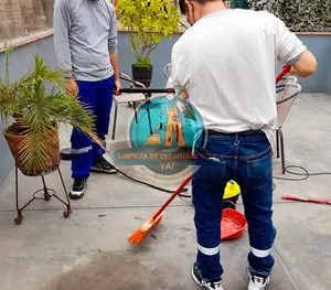 Operarios barriendo y lavando una terraza en una limpieza de final de obra