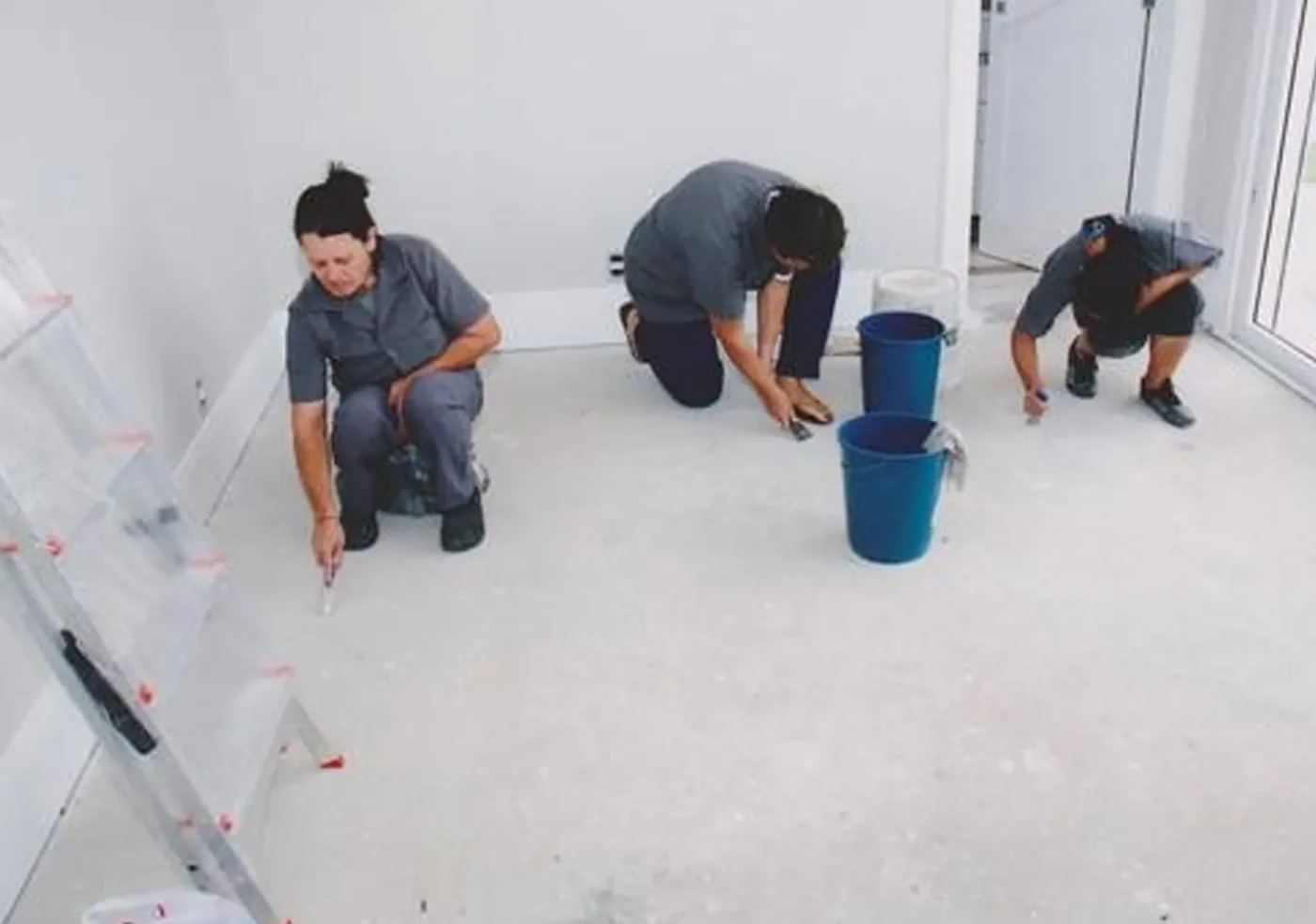 Operarios limpiando ventanas y pisos de un departamento recién construido